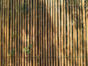 Modern bamboo privacy fence with breeze block base on a patio