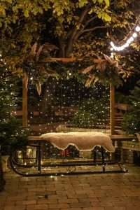 Wooden pergola draped with warm patio string lights